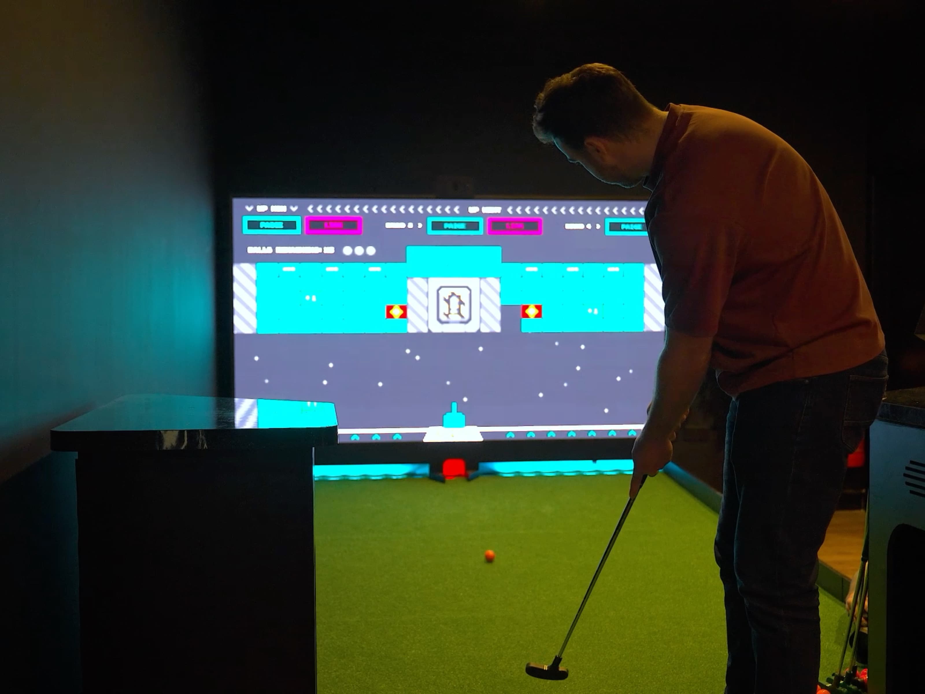 Guest playing the interactive golf simulator at The Upper Court
